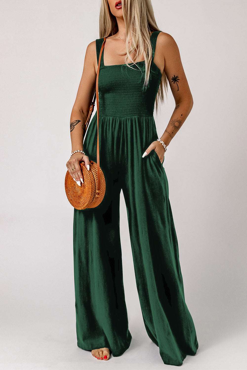 A woman in a wide leg romper holding a round bag, showcasing springtime fashion.