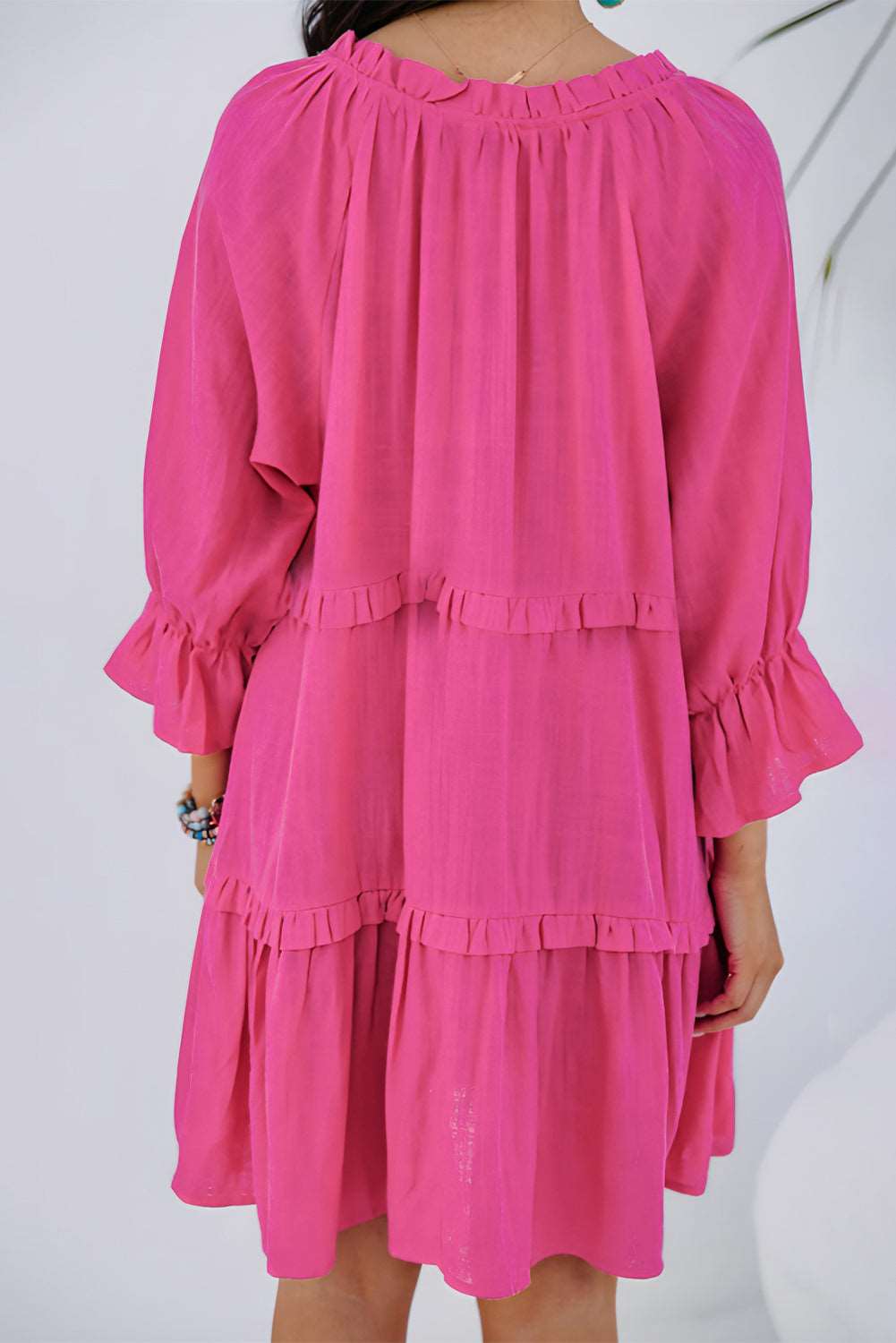 A woman wearing a Romantic Ruffle Pink Mini Dress with frilly accents, exuding a flirty and feminine vibe.